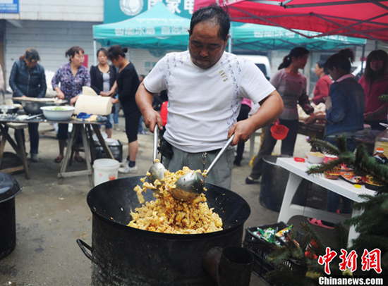 厨师正在用大铁锅炒菜(图片来源:中新网)